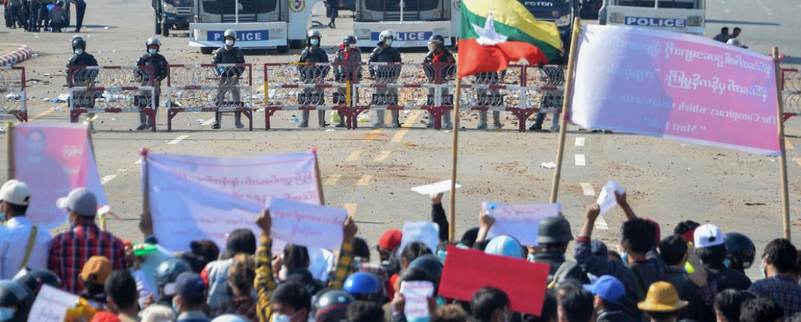 Pro-democracy demonstrators face riot police on an avenue in the capital, Naypyidaw, on 9 February (photo: STR / AFP).